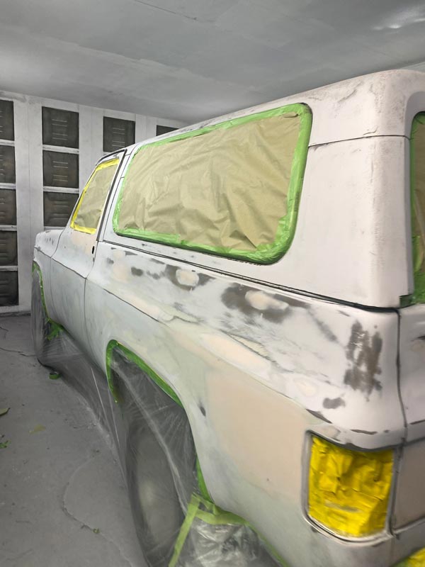 Chevrolet Blazer properly masked and prepped for paint in spray booth