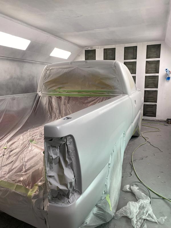 Final paint application stage with controlled spray booth environment