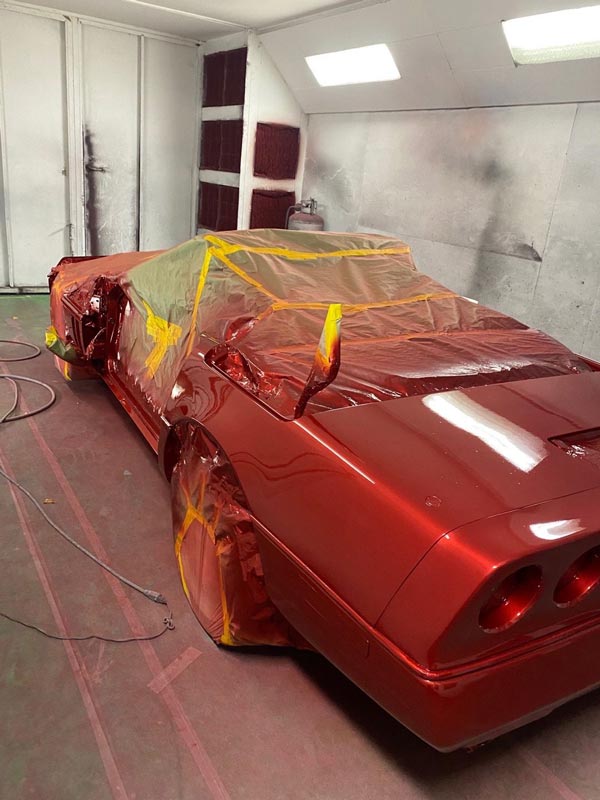 Professional red paint application in spray booth