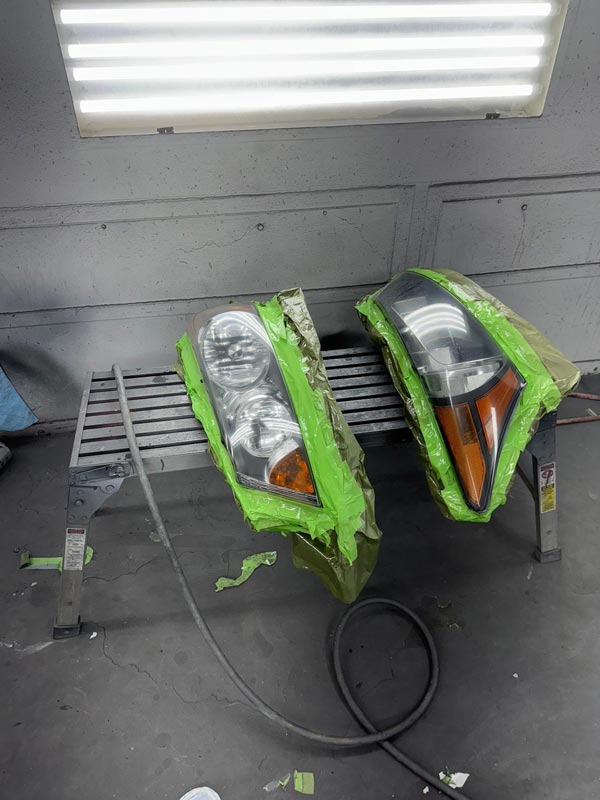 Headlight assemblies masked and prepared for painting