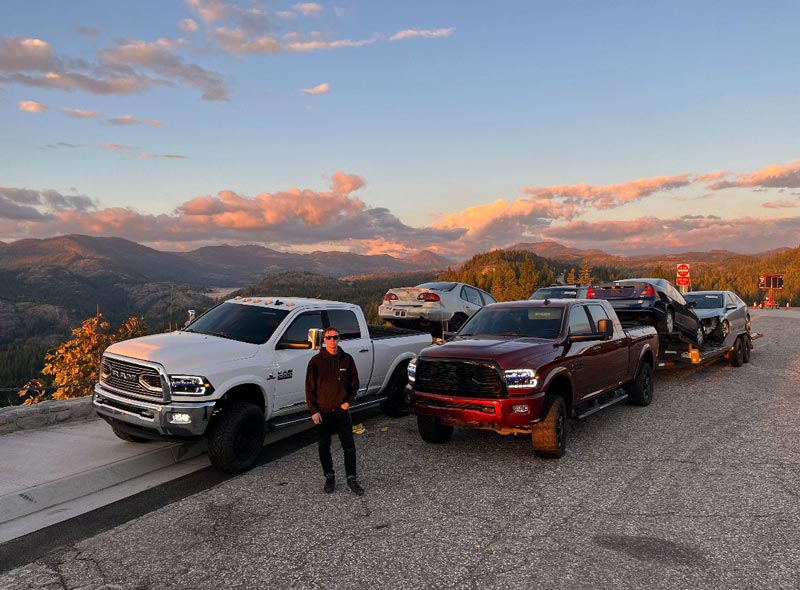 Professional towing operator with fleet of trucks and trailers at mountain location
