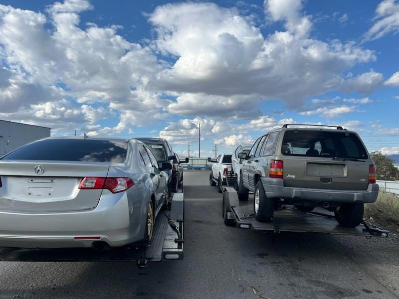 Multiple vehicles loaded on car carrier trailers ready for transport