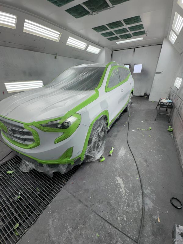Full SUV view in spray booth with comprehensive masking setup