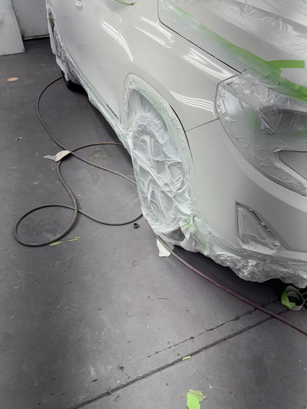 Detail view of wheel well masking and precision paint work